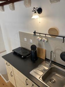 a kitchen counter with a sink and a stove at studio apartment Vicelic in Dubrovnik