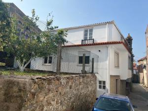 a car parked in front of a white house at Casa Familiar con barbacoa in Finisterre