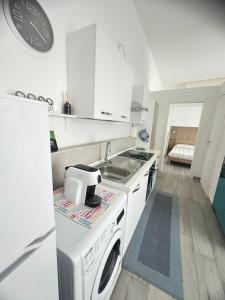 Una cocina blanca con fregadero y estufa. horno superior en Sea House, en Giovinazzo