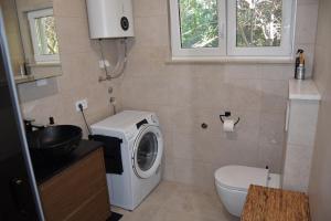 een badkamer met wasmachine en toilet bij Family House Stara Novalja in Stara Novalja +36 foto's
