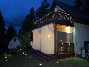 a house with a large window with a white curtain at Eden nad Lubie Linowno in Linowo