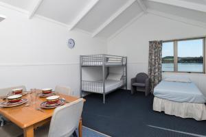 Habitación con mesa, cama y dormitorio. en Waitangi Holiday Park, en Paihia