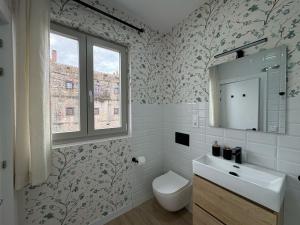a bathroom with a sink and a toilet and a window at Casuca Queveda in Santillana del Mar +29 photos