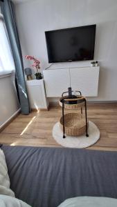 a living room with a tv and a table at Moment détente in Coulogne