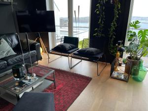 a living room with two black couches and a red rug at Panorama Byfjorden in Stavanger
