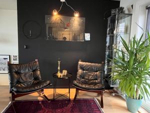 a room with two chairs and a potted plant at Panorama Byfjorden in Stavanger