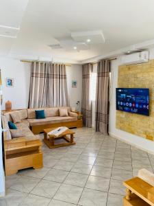 a living room with a couch and a tv at Villa Baya in El Haouaria