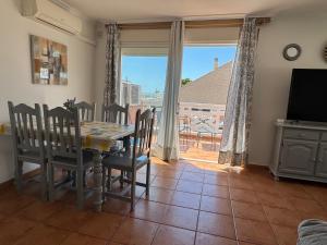a dining room with a table and chairs and a window at Nature Somhome Peñíscola in Peñíscola