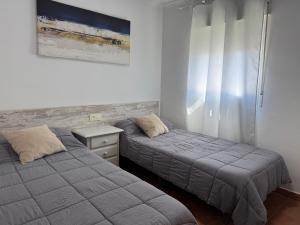 a bedroom with two beds and a nightstand and a bed sidx sidx sidx sidx at Nature Somhome Peñíscola in Peñíscola