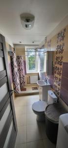 a bathroom with a toilet and a sink and a window at Pernavas street in Rīga