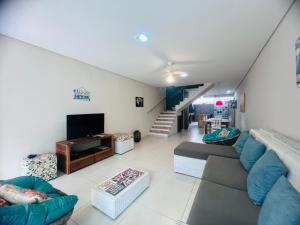 a living room with a couch and a tv at Casa Condomínio Juquehy 100 M do Centrinho in Juquei