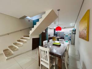 a dining room with a table and a staircase at Casa Condomínio Juquehy 100 M do Centrinho in Juquei
