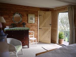 a bedroom with a bed and a mirror and a door at The Lodge On The Marsh in Brading