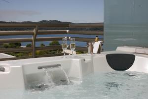 a bath tub with two glasses of wine at Troia Design Hotel in Troia