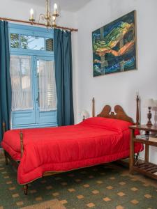 a bedroom with a red bed with a blue door at Casa Chango Hostel in Tandil