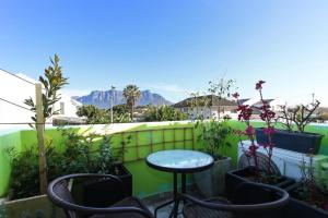 a patio with a table and chairs and plants at Camdene Guesthouse in Cape Town