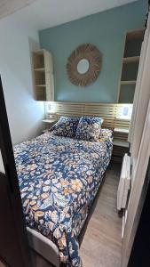 Un dormitorio con una cama y un espejo en la pared. en Appartement 4 à 6 personnes Hyper Centre au Calme dans impasse AVEC PARKING, en Cauterets