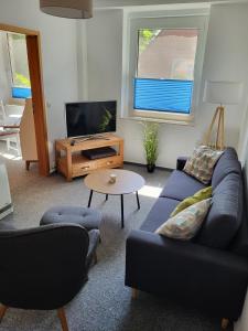 un soggiorno con un divano blu e una TV di Ferienwohnung Kormoran a Kargow