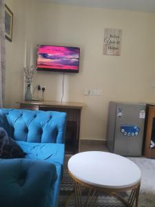 a living room with a blue couch and a table at Regional Homes Ke 1004 in Nairobi