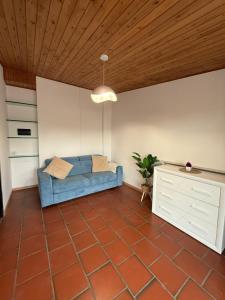 a living room with a blue couch and a wooden ceiling at Grande appartamento Stella Marina in Misano Adriatico