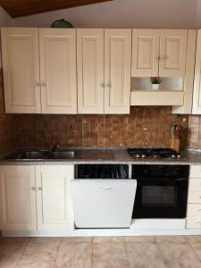 a kitchen with white cabinets and a stove top oven at Grande appartamento Stella Marina in Misano Adriatico