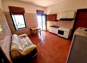 a living room with a couch and a kitchen at VERDE - PROPPRO SRL - MILAZZO FRONTE MAREe in Milazzo