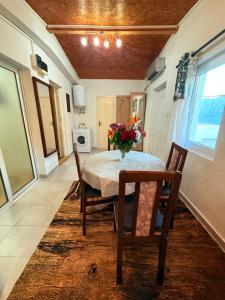 a dining room with a table with a vase of flowers on it at ALISA Sea View Apartment Prcanj in Kotor