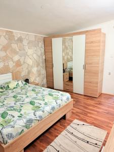 a bedroom with a bed and a stone wall at ALISA Sea View Apartment Prcanj in Kotor