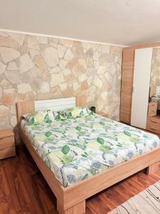 a bed in a room with a stone wall at ALISA Sea View Apartment Prcanj in Kotor