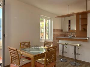 Un comedor con una mesa de cristal y sillas. en Green square apartment Budva, en Budva