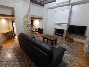a living room with a couch and a fireplace at Casa L'Olivar in Beniardá
