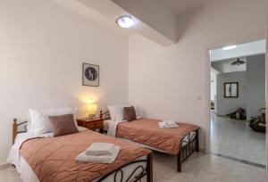 a bedroom with two beds with orange sheets at STEGNA REA Seaside Apartment in Archangelos