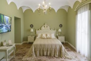 a bedroom with a large bed and a chandelier at Hotel Boutique iulia 5 Estrellas in Zafra