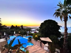 a view of a pool at a resort with a sunset at Madliena Hills Mansion in Is-Swieqi
