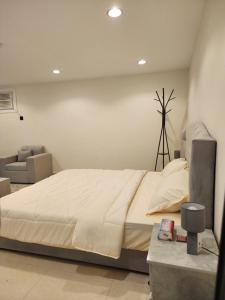 a bedroom with a large bed and a chair at استوديو للايجار in Quai
