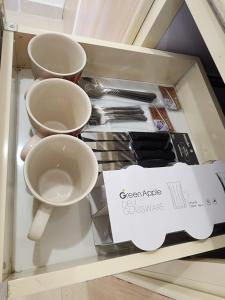 a drawer with three cups and utensils on it at استوديو للايجار in Quai