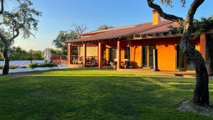 an orange house with a lawn in front of it at Branca Countryside Retreat in Coruche