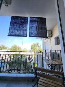 uma varanda com um banco e uma janela em The cosy nest em Asprovalta