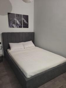 uma cama em um quarto com dois quadros na parede em The cosy nest em Asprovalta