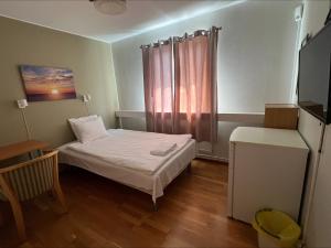 a small room with a bed and a window at IzKaMaGe Hotel in Västerås