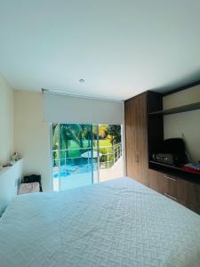 a bedroom with a large bed and a sliding glass door at Condominio El Peñon, Girardot in El Peñón