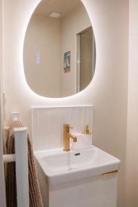 a bathroom with a sink and a mirror at Le Nid Terracotta Charme et Sérénité à Saint-Brieuc in Saint-Brieuc