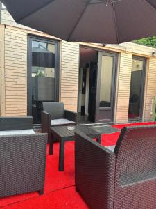 a patio with a table and chairs and an umbrella at Cabanon aux films in Saint-Brieuc
