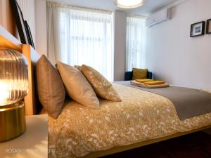 a bedroom with a bed with pillows and a window at rosario inn porto in Porto