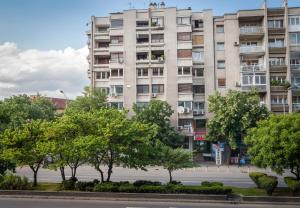 un immeuble d'appartements avec des arbres devant dans l'établissement Valor Apartments, à Skopje