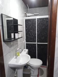 a bathroom with a white toilet and a sink at Loft em São José in São José