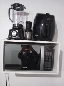 a person taking a picture of a microwave at Loft em São José in São José