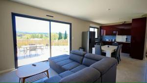 un salon avec un canapé bleu et une cuisine dans l'établissement Cap sur le Ventoux, à Mormoiron 14 autres photos