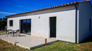 Cette maison blanche dispose d'une terrasse et d'une table. dans l'établissement Cap sur le Ventoux, à Mormoiron