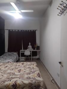 a bedroom with two beds and a desk with a chair at Hospedaje,Descanso soñado in Ezeiza